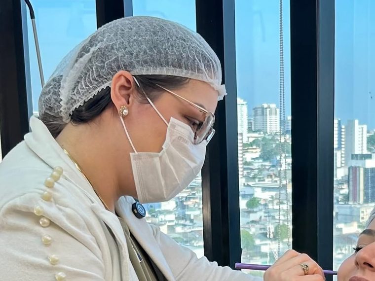 Dra. Aline realizando um procedimento no consultório.